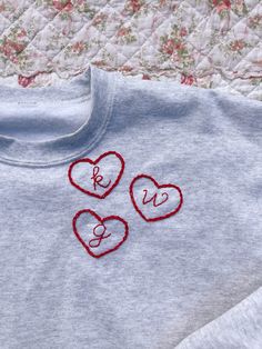 two hearts are embroidered onto the back of a t - shirt