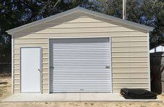 a garage with two doors and one door open in front of a fenced yard