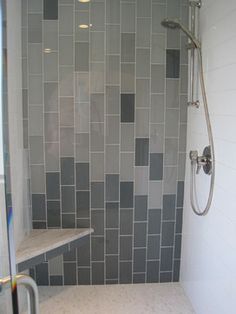 a walk in shower sitting next to a tiled wall