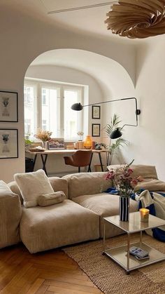 a living room filled with lots of furniture and decor on top of a hard wood floor