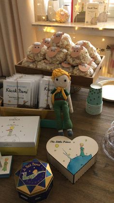 a wooden table topped with boxes and stuffed animals