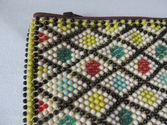 a beaded purse sitting on top of a white table