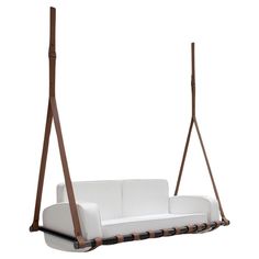 a white couch sitting on top of a wooden frame swing bed with two seats and one armrest