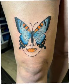 a woman's leg with a blue butterfly on it and an orange lip in the shape of a face