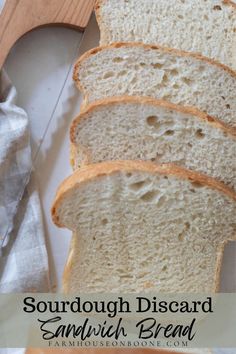 a loaf of sourdough disecarded sandwich bread on a cutting board