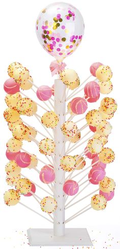 a cake pops stand with a balloon and confetti on it