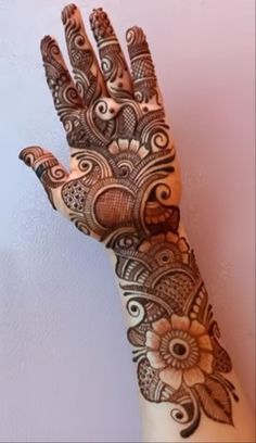 a woman's hand with henna tattoos on it