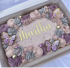 a birthday cake in a box decorated with butterflies and the word mahlha on it