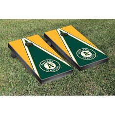 two green and yellow triangle shaped cornhole game pieces on grass with the letter a