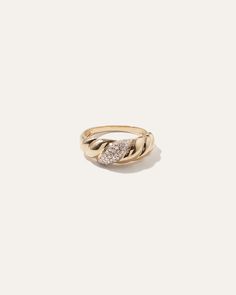 a gold ring with diamonds on the front and side, set against a white background