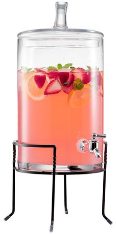 a glass beverage dispenser filled with liquid and fruit on the rims