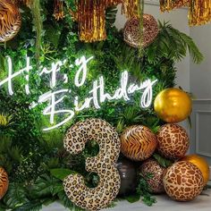 a happy birthday sign surrounded by jungle decorations