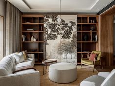 a living room filled with furniture and a painting on the wall above it's bookshelves