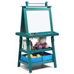 a blue easel with two bins and a stuffed animal in it's lap