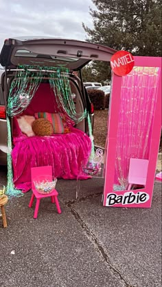 the trunk of a car is decorated with pink and green decorations