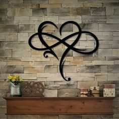 a fireplace with a heart shaped iron decoration on it's mantle next to a brick wall