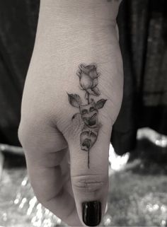 a person's hand with a flower tattoo on it