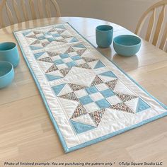 a table runner with blue bowls and cups on it