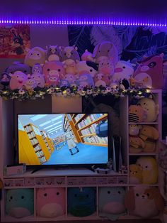 there are many stuffed animals on the television screen in this room, and it looks like they're watching tv