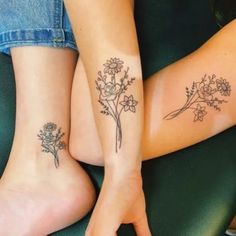 two women with matching tattoos on their legs sitting next to each other and holding hands