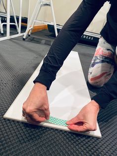 a person standing on top of a piece of white paper with one hand over it