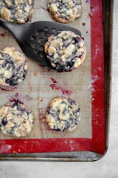 blueberry muffins on a baking sheet with a spatula