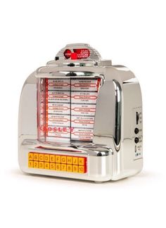 a silver toaster oven sitting on top of a white table next to a red light