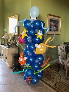 an octopus balloon tree in the middle of a living room with balloons attached to it