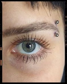 a woman's eye with piercings on it