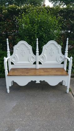 a white bench sitting on top of a sidewalk