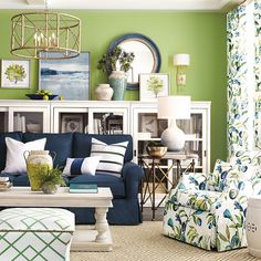 a living room with green walls and blue couches in the center, white coffee table