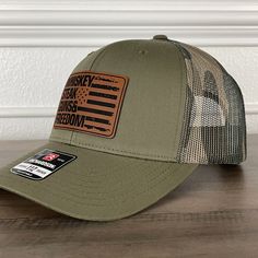 Whiskey Steak Guns & Freedom American Flag Patriotic 2A Leather Patch Hat Green/Camo. Specifications: 🧢 Richardson original 112 trucker; adjustable for the perfect fit ��🎩 60/40 cotton/polyester blend for comfort 📏 One size fits most 🏷️ Expertly laser engraved leatherette patch design 📦 Ships in 2 to 3 business days from our Orlando Studio Care Instructions: 🚫 Do not wash; spot clean only Please Note: 🌈 Colors may vary from photos based on your viewing screen. Whiskey Steak, Orlando Studios, Leather Patch Hat, Patch Hat, Patch Design, Green Camo, Leather Patches, Laser Engraved, Laser Engraving