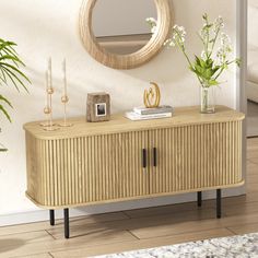 a living room with a mirror, vases and plants on top of the sideboard