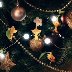 the christmas tree is decorated with gold and silver ornaments, including little giraffes