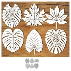 four cut out leaves sitting on top of a wooden table