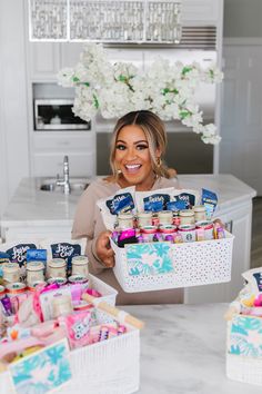 a woman holding a basket full of food in front of a counter top filled with condiments