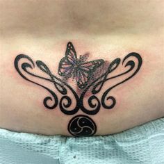 a woman's stomach with a butterfly tattoo on her belly and the letter e