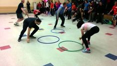 a group of people standing on top of a gym floor with hoop rings in front of them