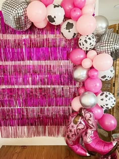 pink and silver balloons are hanging on the wall next to a cowgirl themed backdrop