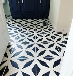 a bathroom with black and white flooring next to a blue cabinet in the corner