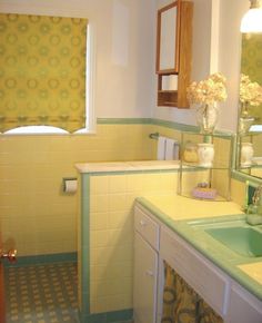 a bathroom with yellow and green tile on the floor, sink, mirror and window