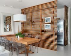 an image of a dining room with wood slats on the wall and chairs around the table