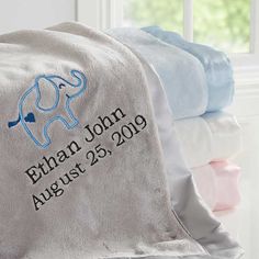 an elephant blanket with the name and date on it is sitting in front of a window