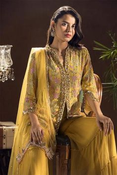 Mustard kurta with floral and sequins embroidered motifs. Paired with tiered sharara and dupatta.
Component: 3
Embroidered
Neckine: V neck
Sleeve Length: Three quarter
Fabric: Crepe,Chiffon
Color: Yellow
Sequins work
Floral motifs
Sheer dupatta
Resham embroidery - Aza Fashions Traditional Wear For Women, Mustard Shirt, Zardozi Work, Asim Jofa, Sanya, Sharara Set, Pakistani Suits, Embroidery Suits, Traditional Wear