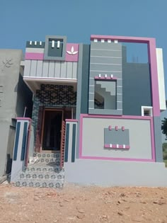 a building that is painted in shades of purple and grey with stairs leading up to the front door