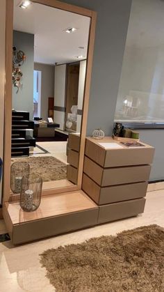 a large mirror sitting on top of a wooden shelf next to a chair and table