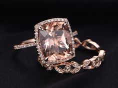 an engagement ring with a large cushion cut morganite surrounded by white diamonds on a black background