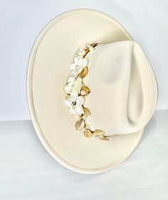 This is one of a kind ivory fedora  with a velvet trim detail and beautiful flower, pearl and gold petal applicate.  Making this item such a unique and rare item.  Perfect for any fancy occasion or to dress up an outfit.   All of my work is original and one of a kind. All rights are reserved to she is blooming.   Ivory velvet trim ONE SIZE   Wide brim  Vegan hat Can be adjusted to make smaller    She is blooming does not accept returns, exchanges or cancellations. Due to lighting  Color can appear  slightly different. Luxury Cream Fedora For Formal Occasions, Elegant Handmade Short Brim Fedora, Elegant Handmade Fedora With Short Brim, Elegant Handmade Fedora With Curved Brim, Handmade Elegant Fedora With Curved Brim, Elegant White Adjustable Fedora, Elegant Handmade Adjustable Fedora, Handmade Elegant Fedora For Kentucky Derby, Handmade Elegant Wide Brim Hat Bands