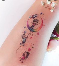 a woman's leg with a tattoo on it that has an image of two children flying