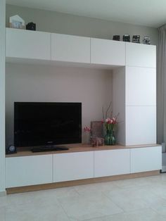 a flat screen tv sitting on top of a white entertainment center